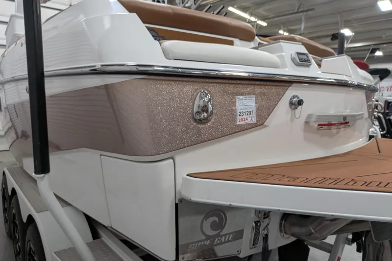 Slide: The Image of 2021 Malibu M240 boat with sleek design and Surf Gate technology in showroom. - 11