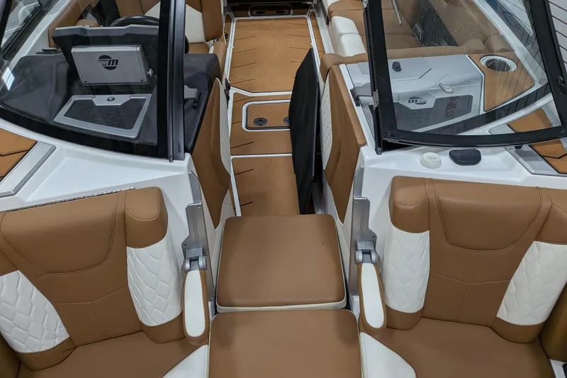Slide: The Image of 2021 Malibu M240 boat interior with tan and white seating, modern design. - 18