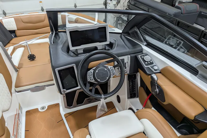 Slide: The Image of Interior of a 2021 Malibu M240 boat with modern dashboard and tan seating. - 30