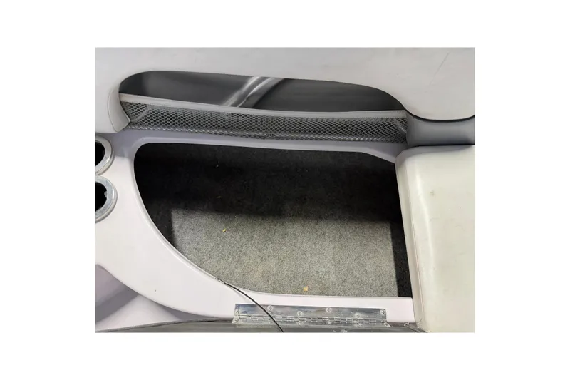 Slide: The Image of Interior of 2004 Nautique Sport Nautique SV-211 boat, featuring carpeted flooring and storage net. - 10