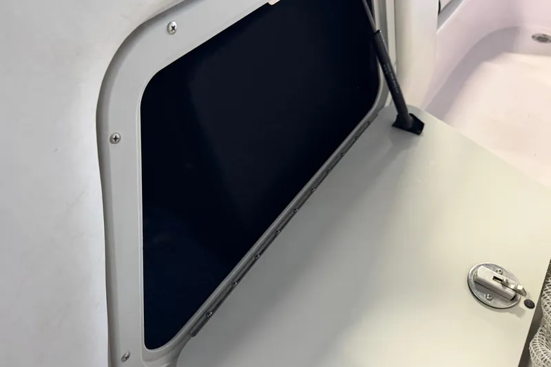 Slide: The Image of Storage compartment of 2004 Nautique Sport Nautique SV-211 boat, featuring a secure latch. - 14