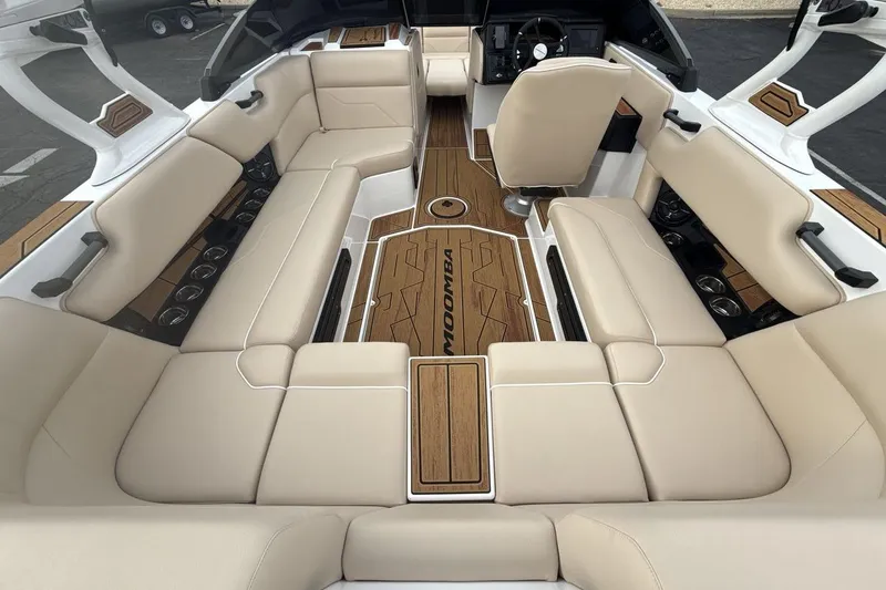 Slide: The Image of 2026 Moomba Max boat interior with beige seating and wood accents. - 10