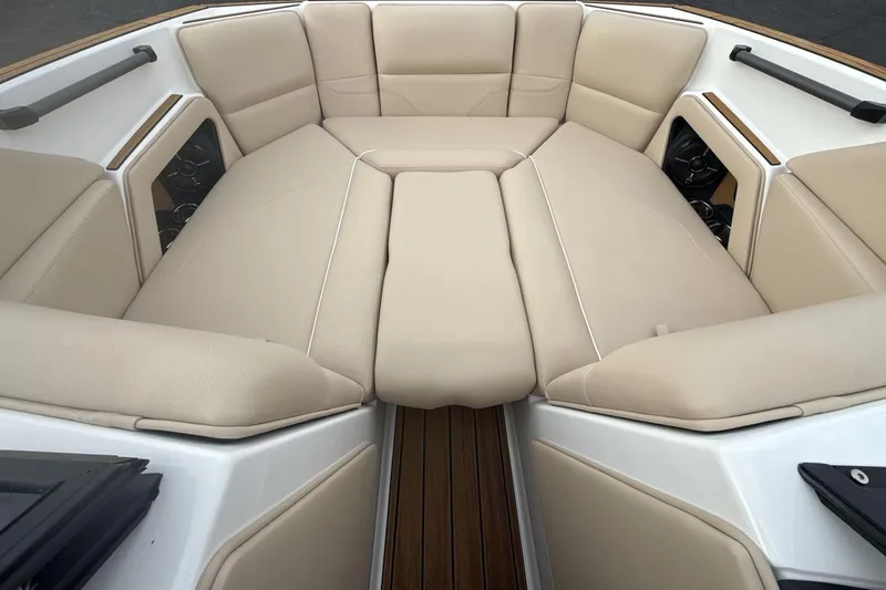 Slide: The Image of 2026 Moomba Max boat interior with beige cushioned seating and wood accents. - 11