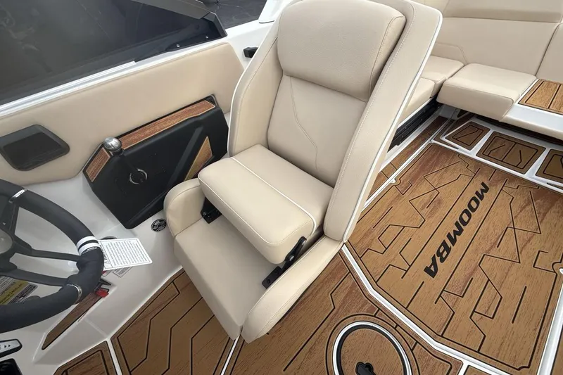 Slide: The Image of 2026 Moomba Max boat interior with beige seating and wood-patterned flooring. - 13