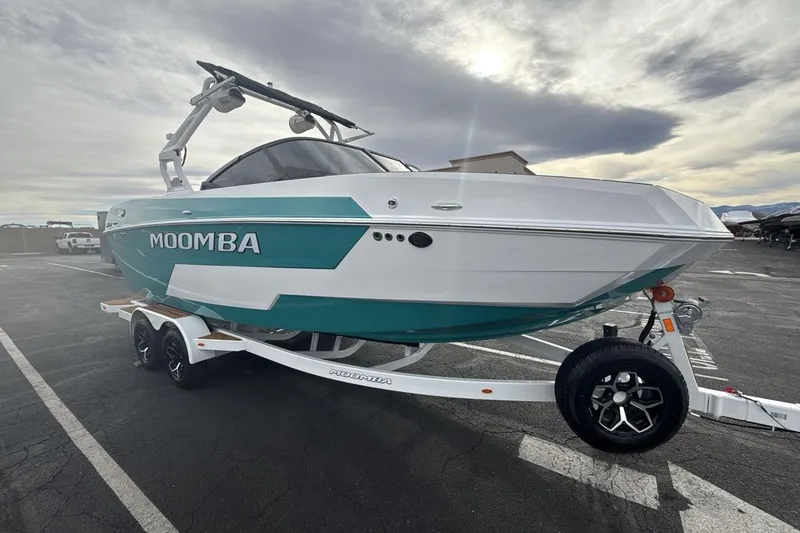 Slide: The Image of 2026 Moomba Max boat on trailer, teal and white design, parked outdoors. - 7