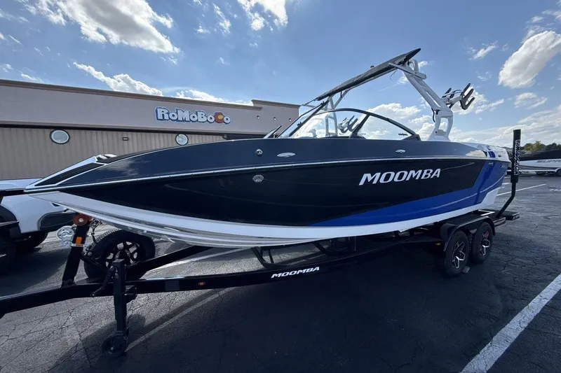 The Image of 2025 Moomba Mojo boat on trailer, parked outside RoMoBoCo building under a clear sky. - 1