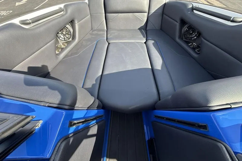 Slide: The Image of 2025 Moomba Mojo boat interior with blue and gray seating, featuring built-in speakers. - 11