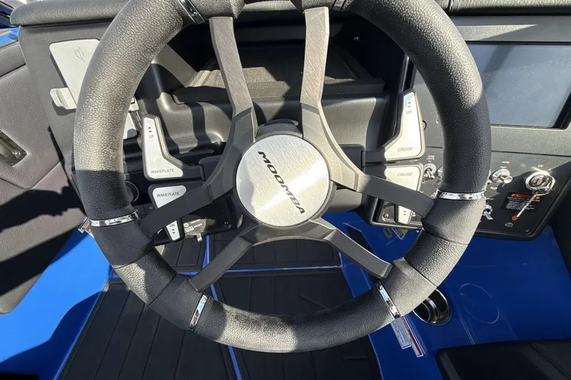 Slide: The Image of Steering wheel of 2025 Moomba Mojo boat with control buttons and sleek design. - 14