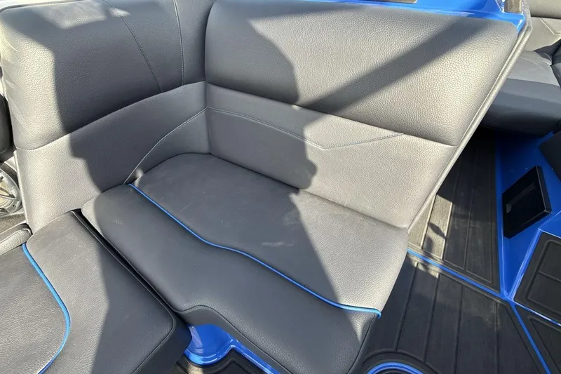 Slide: The Image of 2025 Moomba Mojo boat interior with black leather seating and blue accents. - 17