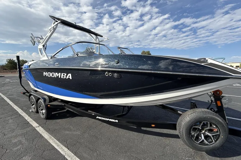 Slide: The Image of 2025 Moomba Mojo boat on trailer under a partly cloudy sky. - 7