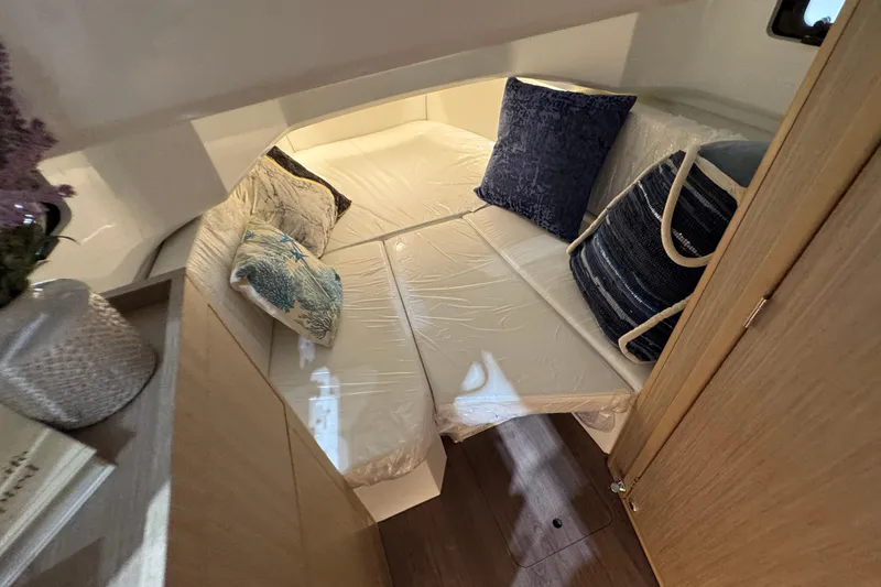 Slide: The Image of Cozy cabin interior of 2026 Jeanneau Leader 10.5 CC with cushions and wooden accents. - 12