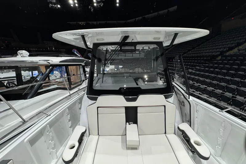 Slide: The Image of 2026 Jeanneau Leader 10.5 CC boat interior with seating and helm, showcased indoors. - 24