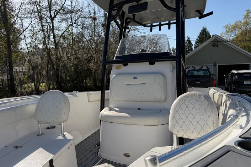 Slide: The Image of 2020 Sportsman Open 212 Center Console boat with white seating and console in a driveway. - 6