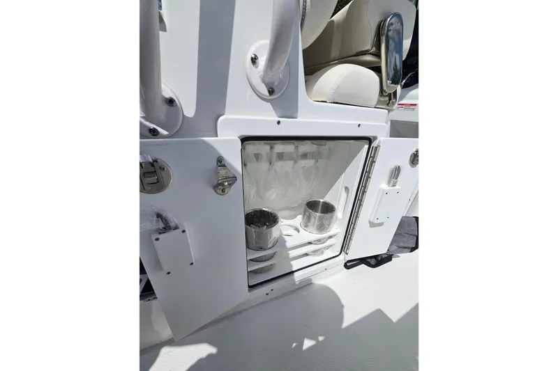 Slide: The Image of Storage compartment on 2025 Sea Hunt Ultra 275 SE boat, featuring cup holders and seating. - 13