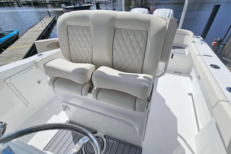 Slide: The Image of Luxurious seating on 2025 Sea Hunt Ultra 275 SE boat, docked by the water. - 16