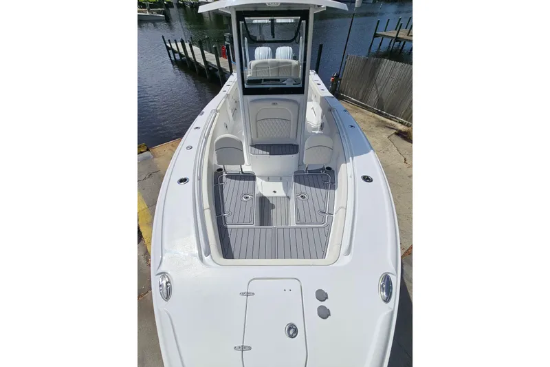 Slide: The Image of 2025 Sea Hunt Ultra 275 SE boat docked, showcasing spacious deck and seating. - 24