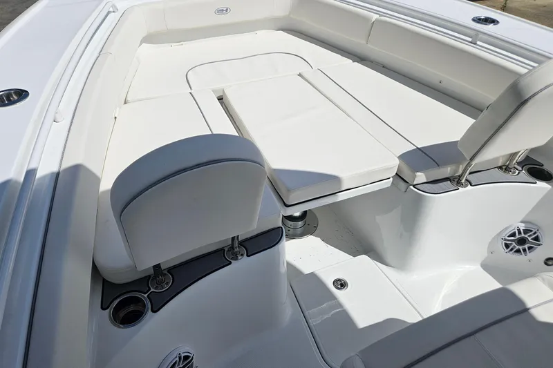 Slide: The Image of 2025 Sea Hunt Ultra 275 SE boat interior with white cushioned seating and table. - 25