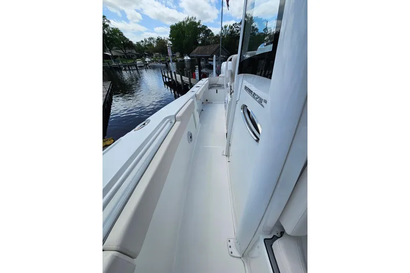 Slide: The Image of 2025 Sea Hunt Ultra 275 SE boat docked by a serene waterfront. - 29