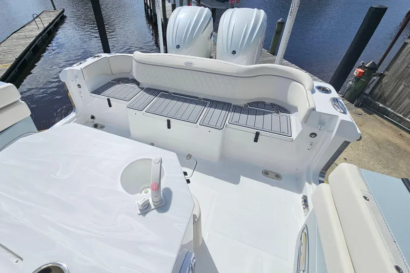 Slide: The Image of 2025 Sea Hunt Ultra 275 SE boat interior with seating and dual engines at dock. - 7