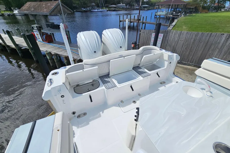 Slide: The Image of 2025 Sea Hunt Ultra 275 SE boat with dual engines docked by a serene waterfront. - 9