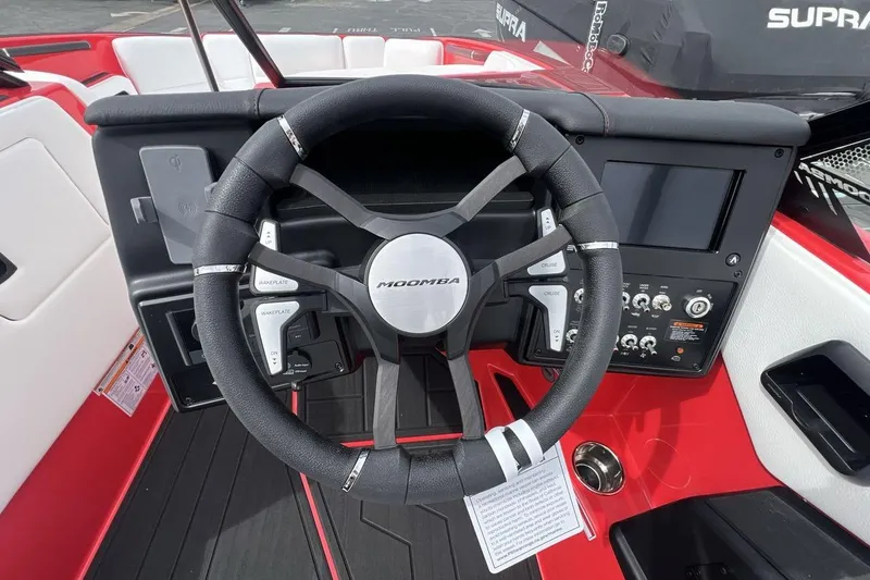 Slide: The Image of Steering wheel and dashboard of 2025 Moomba Max boat, featuring modern controls and sleek design. - 14