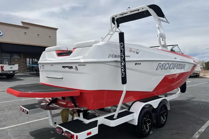 Slide: The Image of 2025 Moomba Max boat on trailer, white and red design, parked outdoors. - 5