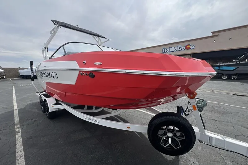 Slide: The Image of 2025 Moomba Max boat in vibrant red on a trailer, parked outdoors. - 7