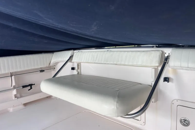 Slide: The Image of 2004 Grady-White Tournament 225 boat interior with foldable seating and white upholstery. - 10
