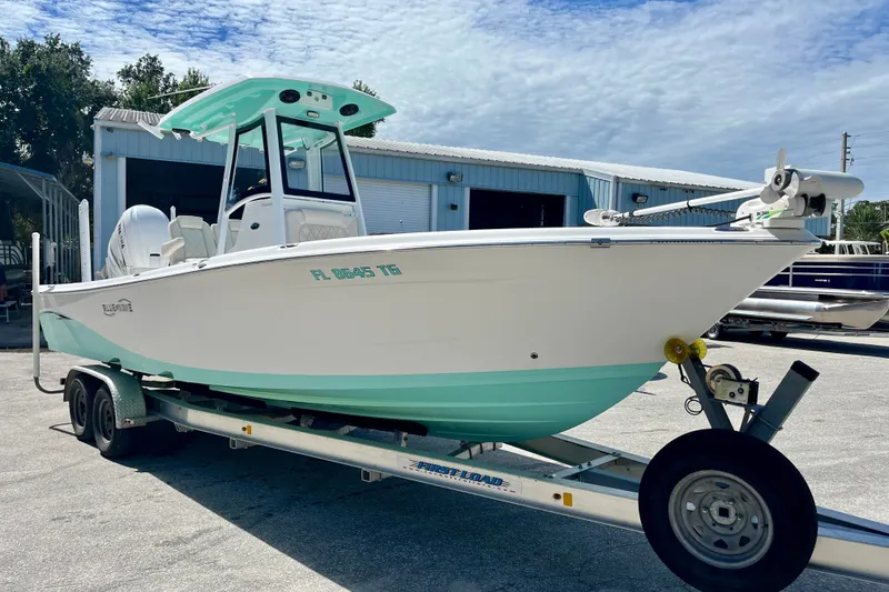 Slide: The Image of 2022 Blue Wave 2800 Pure Hybrid boat on trailer, parked outdoors. - 4