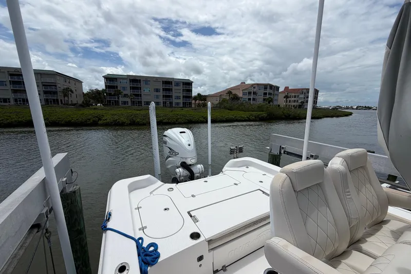 Slide: The Image of 2022 Blue Wave 2800 Pure Hybrid boat docked by waterfront homes under cloudy sky. - 11