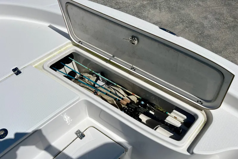 Slide: The Image of Open storage compartment on 2022 Blue Wave 2800 Pure Hybrid boat, holding fishing rods. - 21