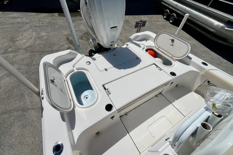 Slide: The Image of 2022 Blue Wave 2800 Pure Hybrid boat deck with storage compartments and motor. - 11