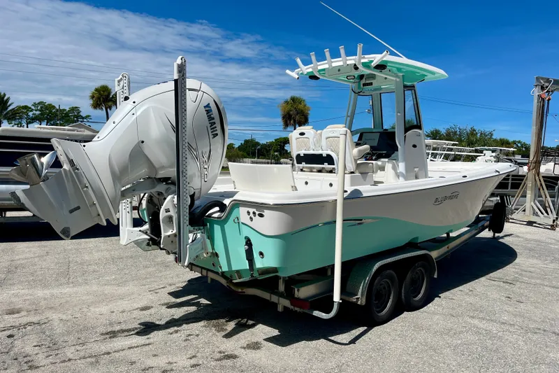 Slide: The Image of 2022 Blue Wave 2800 Pure Hybrid boat with Yamaha engine on trailer, parked outdoors. - 6