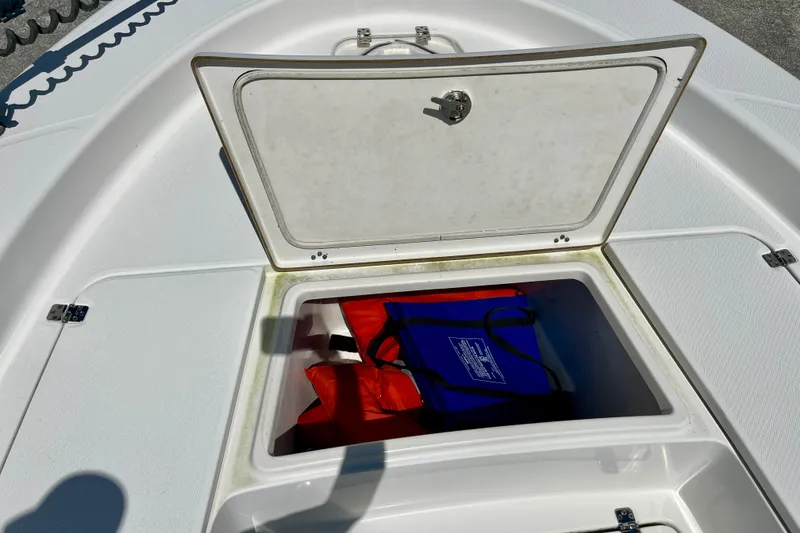 Slide: The Image of Open storage compartment on 2022 Blue Wave 2800 Pure Hybrid boat with life jackets inside. - 23