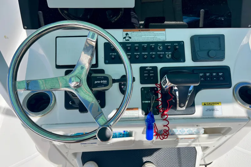 Slide: The Image of Control panel of a 2022 Blue Wave 2800 Pure Hybrid boat with steering wheel and throttle. - 18