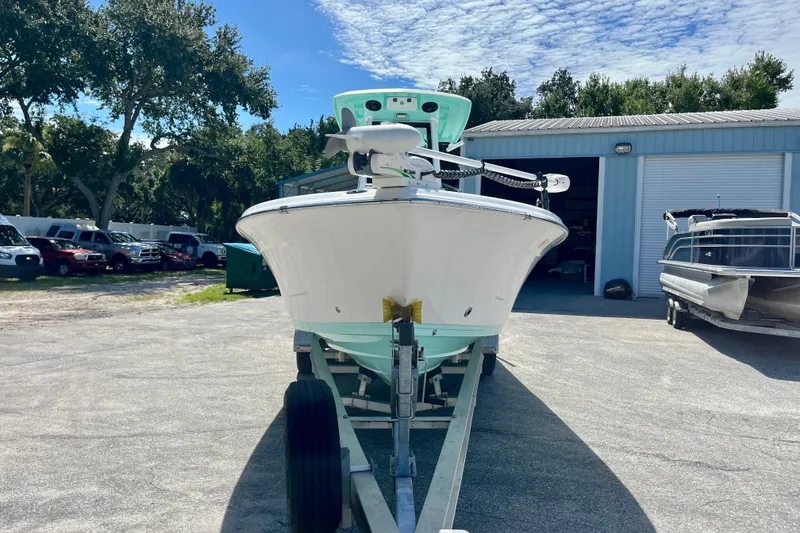 Slide: The Image of 2022 Blue Wave 2800 Pure Hybrid boat on trailer, parked outdoors near a storage facility. - 3
