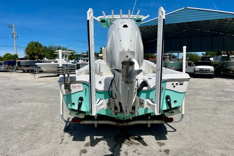 Slide: The Image of 2022 Blue Wave 2800 Pure Hybrid boat, rear view, parked outdoors under clear blue sky. - 7