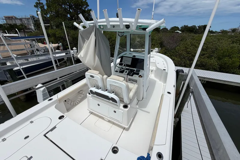 Slide: The Image of 2022 Blue Wave 2800 Pure Hybrid boat docked, featuring a sleek white design and modern console. - 9