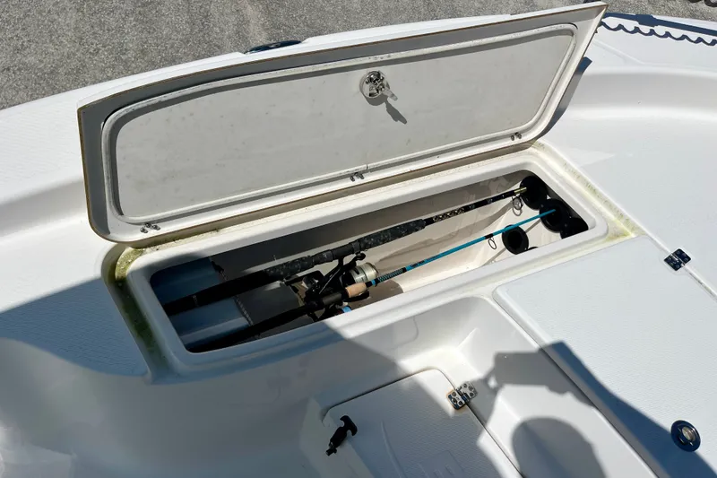 Slide: The Image of Open storage compartment on 2022 Blue Wave 2800 Pure Hybrid boat, revealing fishing gear. - 22