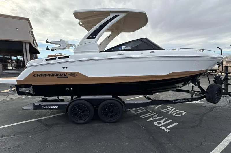 Slide: The Image of 2026 Chaparral GTS 6 boat on trailer, white and brown design, parked outdoors. - 6