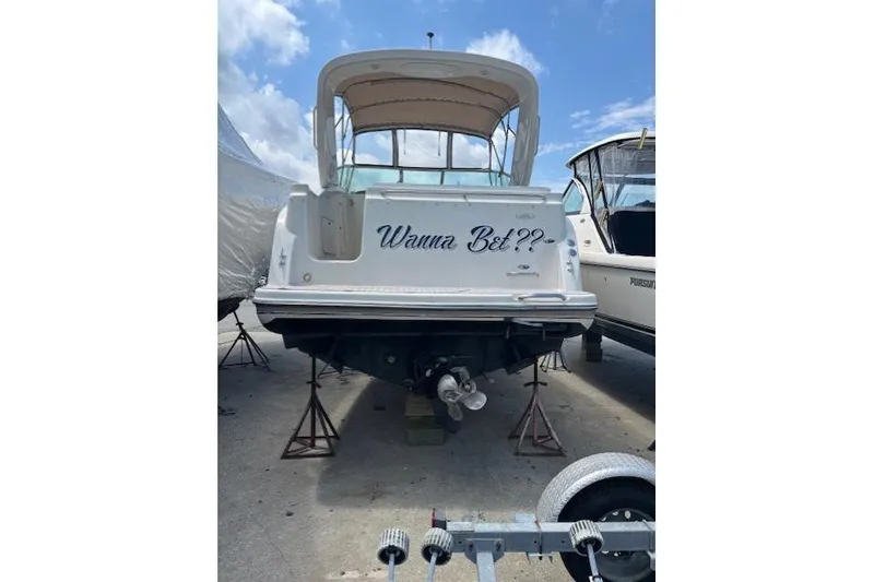 Slide: The Image of 2001 Maxum 2900 SCR boat on stands, rear view with "Wanna Bet?" text. - 4