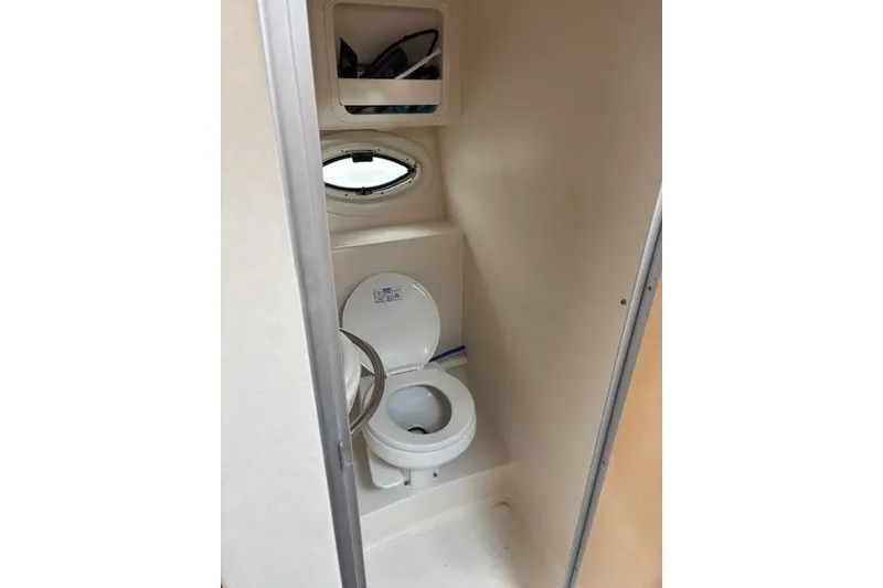 Slide: The Image of 2001 Maxum 2900 SCR boat bathroom with toilet and storage shelves. - 9