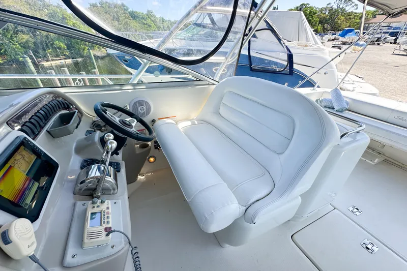 Slide: The Image of 2006 Sea Ray 290 Amberjack helm with white seating and navigation controls. - 10