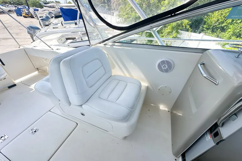 Slide: The Image of 2006 Sea Ray 290 Amberjack interior with white seating and speaker detail. - 12