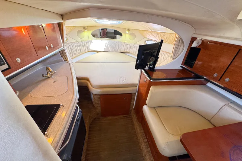 Slide: The Image of 2006 Sea Ray 290 Amberjack cabin interior with kitchenette, seating, and bed. - 13