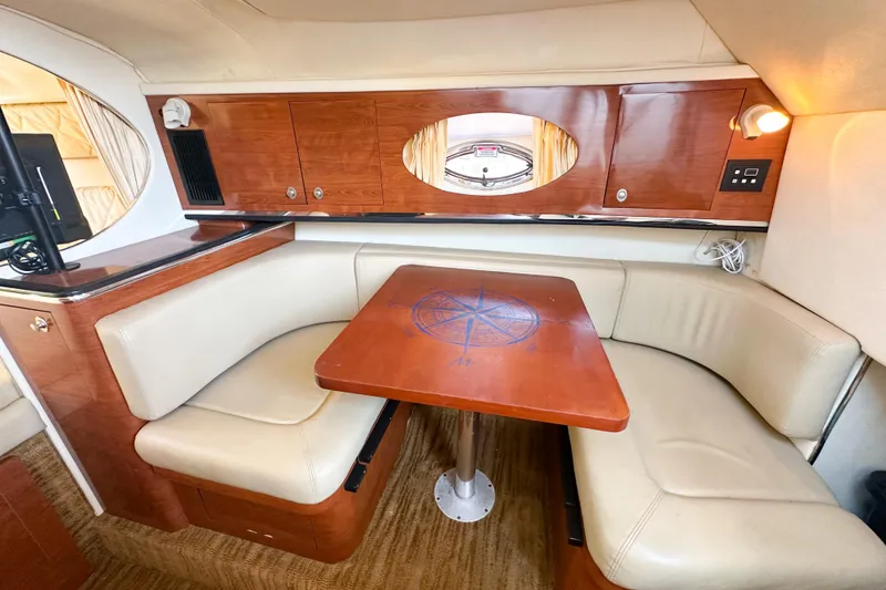 Slide: The Image of Interior of 2006 Sea Ray 290 Amberjack with cozy seating and wooden table. - 14