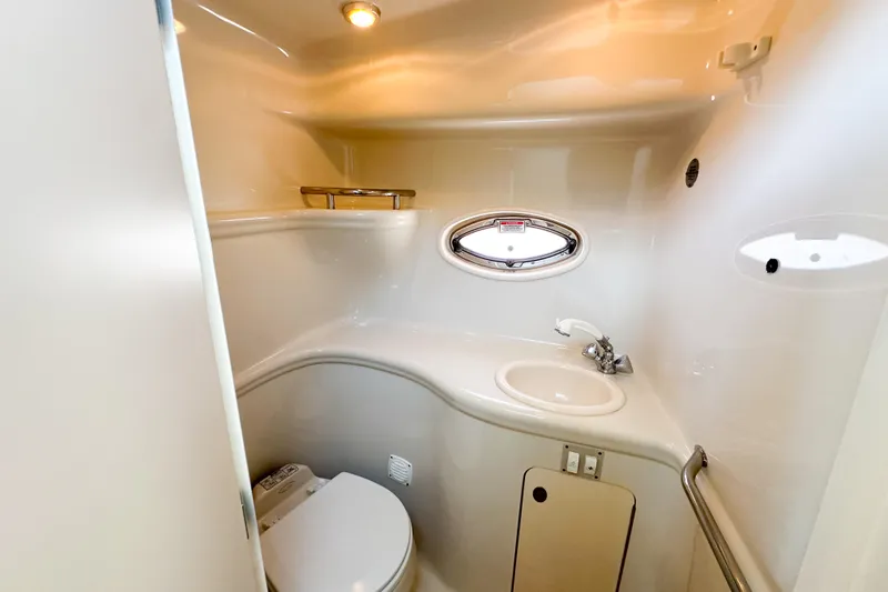 Slide: The Image of 2006 Sea Ray 290 Amberjack boat bathroom with sink, toilet, and porthole window. - 19