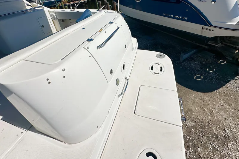 Slide: The Image of 2006 Sea Ray 290 Amberjack boat deck, featuring clean white surface and storage compartments. - 2