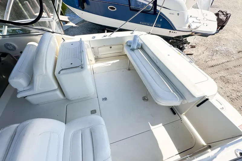 Slide: The Image of 2006 Sea Ray 290 Amberjack boat interior with white seating and storage compartments. - 26