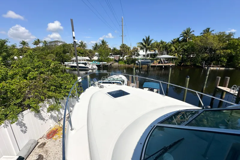 Slide: The Image of 2006 Sea Ray 290 Amberjack docked by a scenic canal with lush greenery. - 28